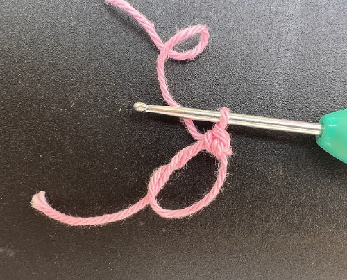 Pembe iple iki kat sarılmış sihirli halka ve tığdaki ilk ilmek