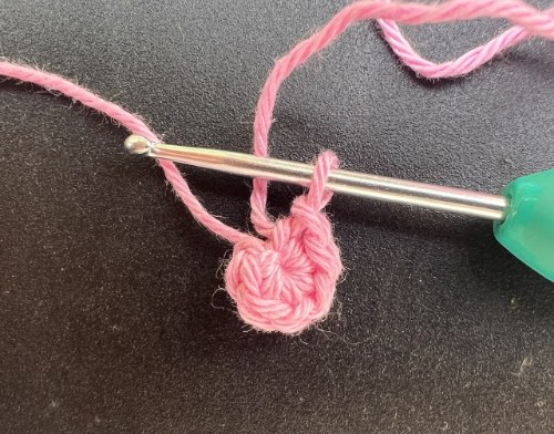 Pembe iple sihirli halkaya örülmüş sık iğneler ve tığ